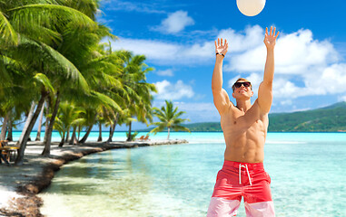 Image showing young man with ball playing volleyball on beach