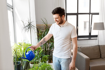 Image showing man watering houseplants at home