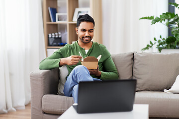 Image showing indian man with laptop eating takeout food at home