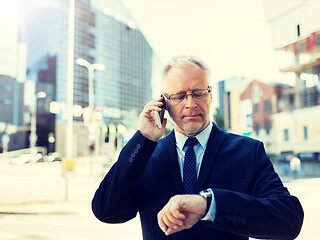 Image showing senior businessman calling on smartphone in city