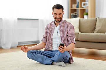 Image showing man in earphones listening to music and meditating