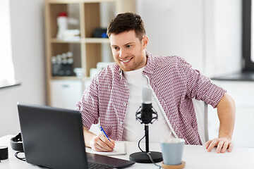 Image showing audio blogger with laptop, microphone and notebook