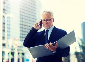 Image showing senior businessman calling on smartphone in city