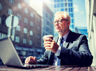 Image showing senior businessman with laptop drinking coffee