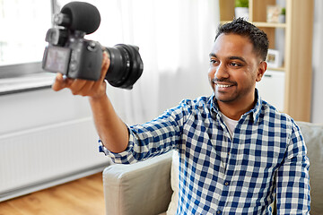 Image showing male video blogger with camera blogging at home