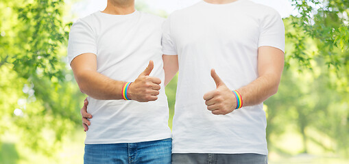 Image showing gay couple with rainbow wristbands shows thumbs up