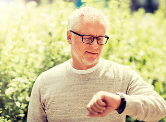 Image showing senior man checking time on his wristwatch