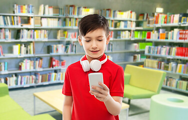 Image showing boy with headphones and smartphone at library