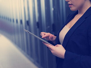 Image showing Female engineer working on a tablet computer in server room