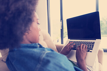 Image showing African American women at home in the chair using a laptop