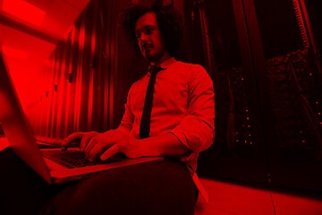 Image showing engineer working on a laptop in server room