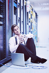 Image showing businessman with laptop in network server room