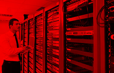 Image showing businessman with laptop in network server room