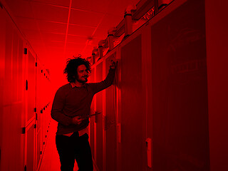 Image showing IT engineer working on a tablet computer in server room