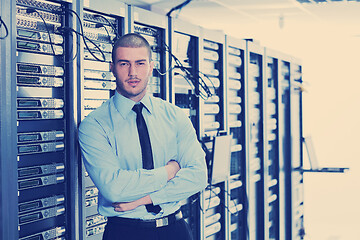 Image showing businessman with laptop in network server room