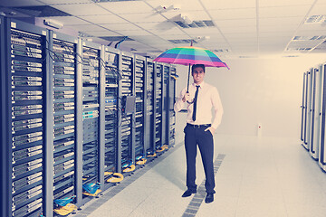 Image showing businessman hold umbrella in server room