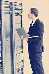 Image showing businessman with laptop in network server room