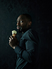 Image showing Portrait of afro american man holding ice cream