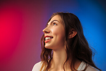 Image showing The happy woman standing and smiling against colored background.