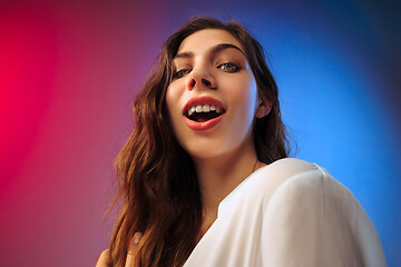 Image showing The happy woman standing and smiling against colored background.