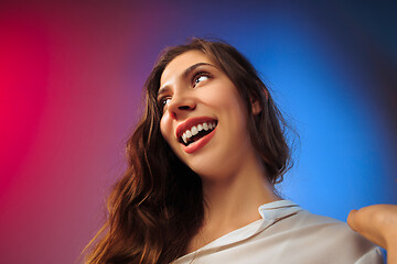 Image showing The happy woman standing and smiling against colored background.