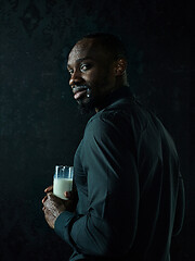 Image showing Healthy young african man holging milk