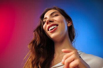 Image showing The happy woman standing and smiling against colored background.