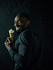 Image showing Portrait of afro american man holding ice cream