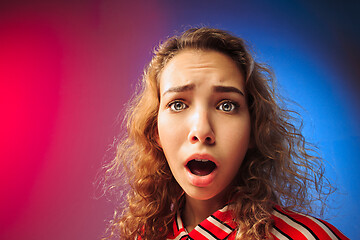 Image showing The serious sad woman standing and looking at camera against colorful background.