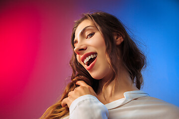 Image showing The happy woman standing and smiling against colored background.