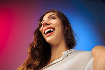Image showing The happy woman standing and smiling against colored background.