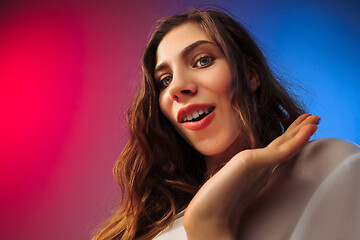 Image showing The happy woman standing and smiling against colored background.