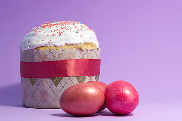 Image showing Easter cake decorated with pink decor and rose-colored eggs on a purple background