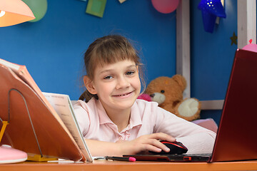 Image showing Happy girl works in a laptop in her children\'s room