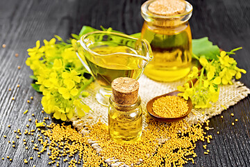 Image showing Oil mustard in two jars and gravy boat on wooden board