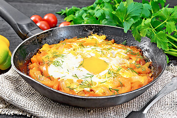 Image showing Scrambled eggs with vegetables in pan on black board