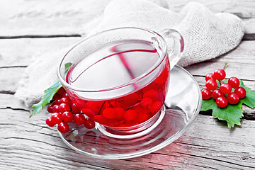 Image showing Tea from viburnum in cup with berries on wooden board