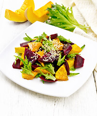 Image showing Salad of pumpkin and beetroot in plate on wooden board