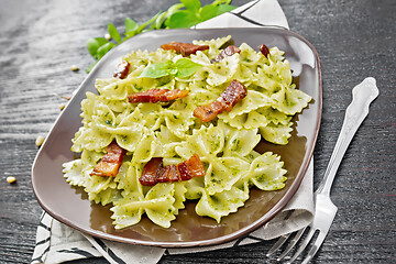 Image showing Farfalle with pesto and bacon on dark board