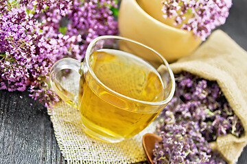 Image showing Tea of oregano in cup with mortar on board