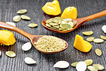 Image showing Flour and seeds pumpkin in spoons on dark board