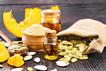 Image showing Oil pumpkin in vial with flour on wooden board