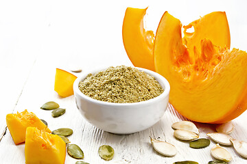 Image showing Flour pumpkin in white bowl on light wooden board