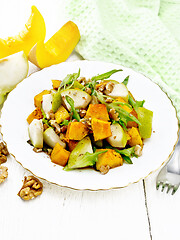 Image showing Salad of pumpkin and pear in plate on light wooden board