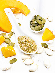 Image showing Flour and seeds pumpkin in spoons on light wooden board