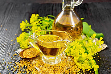 Image showing Oil mustard in gravy boat and decanter on board