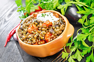 Image showing Lentils with eggplant and tomatoes in bowl on black board