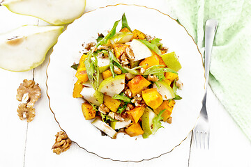 Image showing Salad of pumpkin and pear in plate on board top