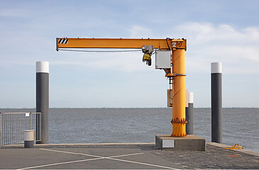 Image showing Yellow boat lift in an harbor