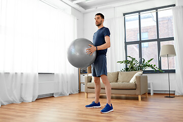 Image showing man exercising with fitness ball at home